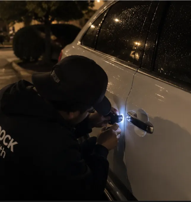 Technician working on a vehicle door lock at night